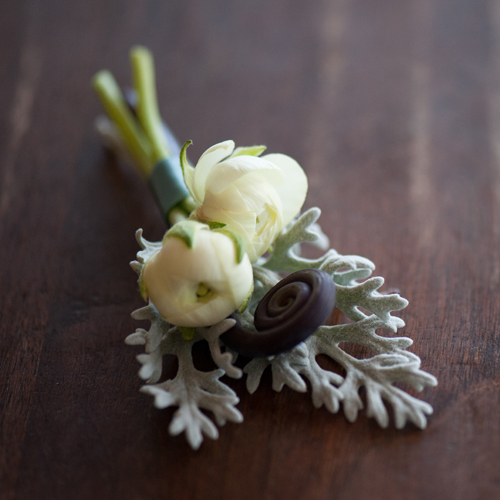 boutonniere with ivory ranunculus, uhule fern curl and dusty miller, by Floral Verde LLC