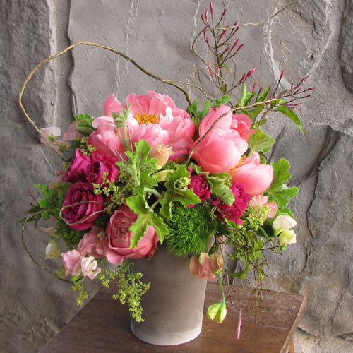 Centerpiece with curly willow branches, jasmine vine, David Austin 'Darcey' garden roses, Hot Majolika spray roses, Coral Charm peonies, Romantic Antike garden roses, peach sweet peas, alchemilla, Green Trick dianthus, scented geranium and Jade trachelium
