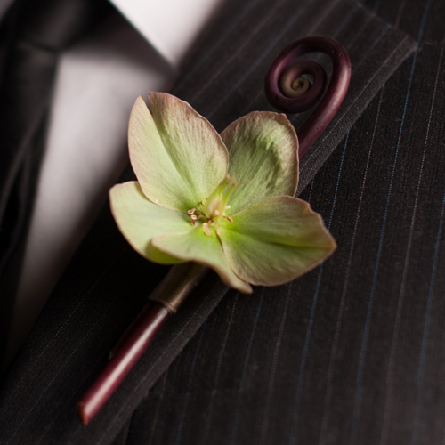 boutonniere with a pink/green/beige hellebore and a uhule fern curl, by Floral Verde LLC